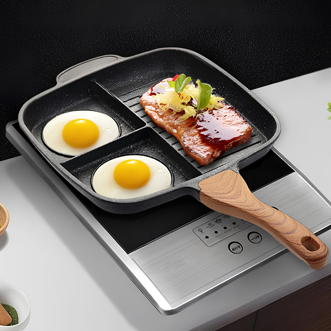 Multi-compartment frying pan with wooden handle on induction cooktop preparing breakfast