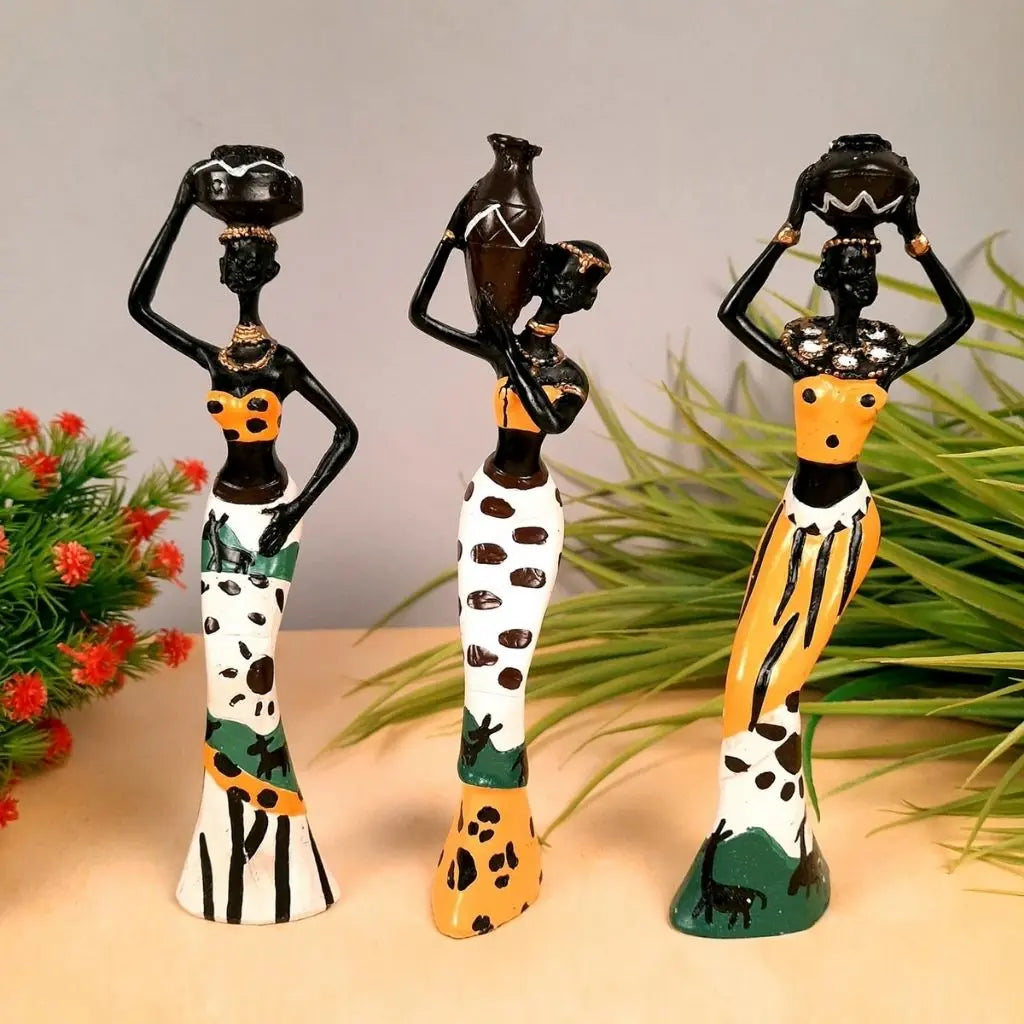 Hand-painted African woman statues balancing pots on heads in colorful patterned skirts