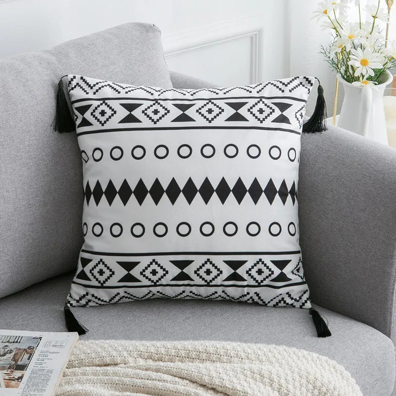 Boho black and white diamond pattern cushion with corner tassels on living room sofa