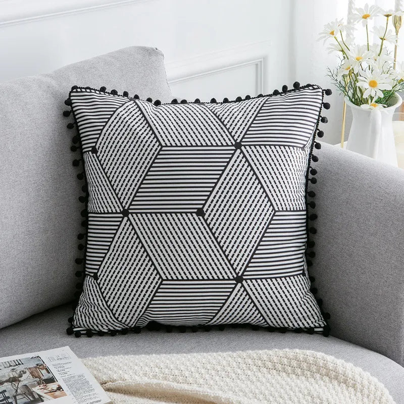 Intersecting hexagonal and diamond panel throw pillow with black pom-pom border