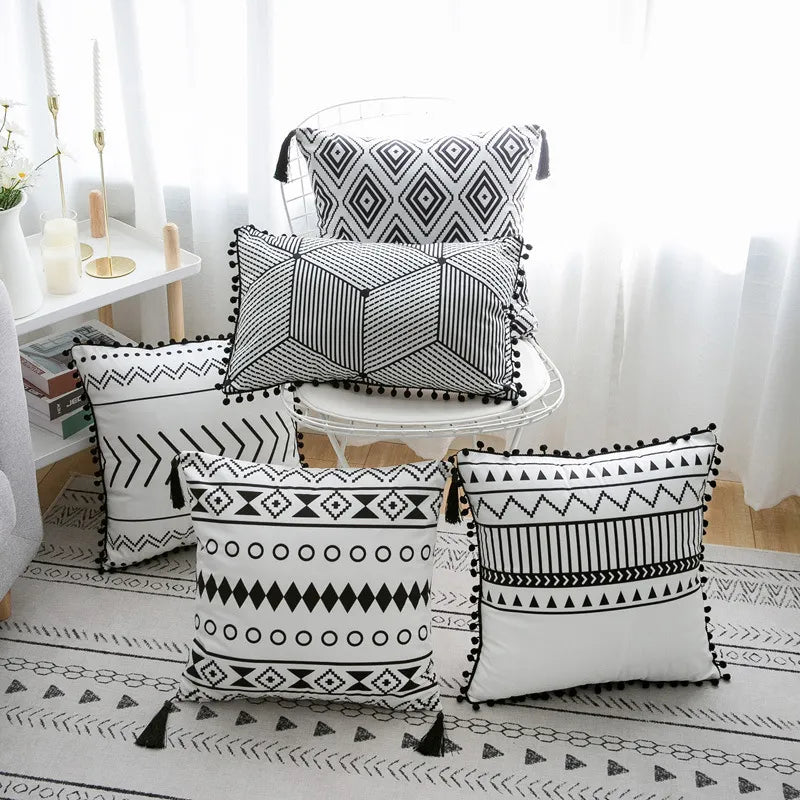 Set of five black and white geometric bohemian throw pillows with pom-poms and tassels
