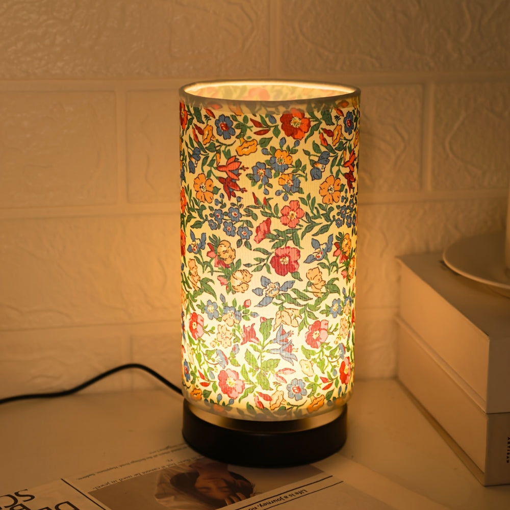 Vibrant vintage floral table lamp casting warm glow through semi-translucent fabric