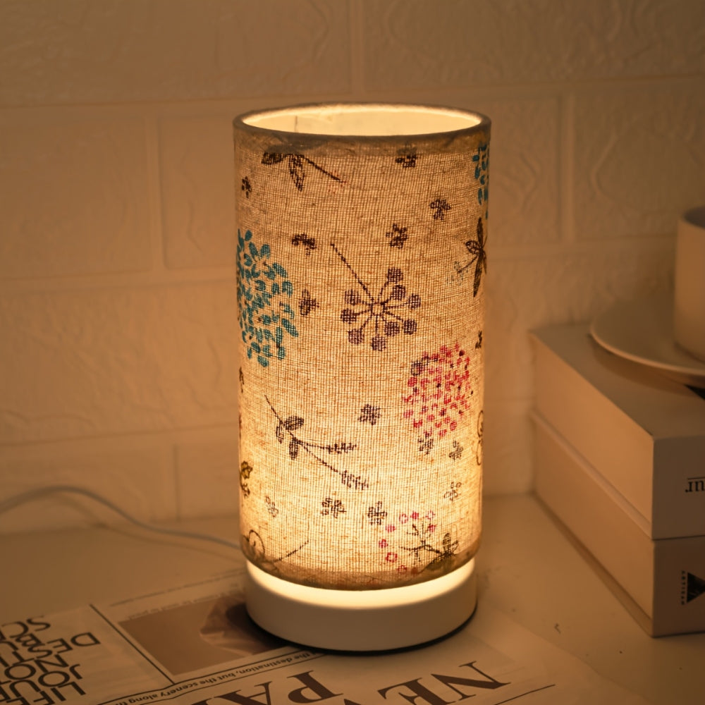 Boho beige linen table lamp with scattered insect and floral motifs in warm light
