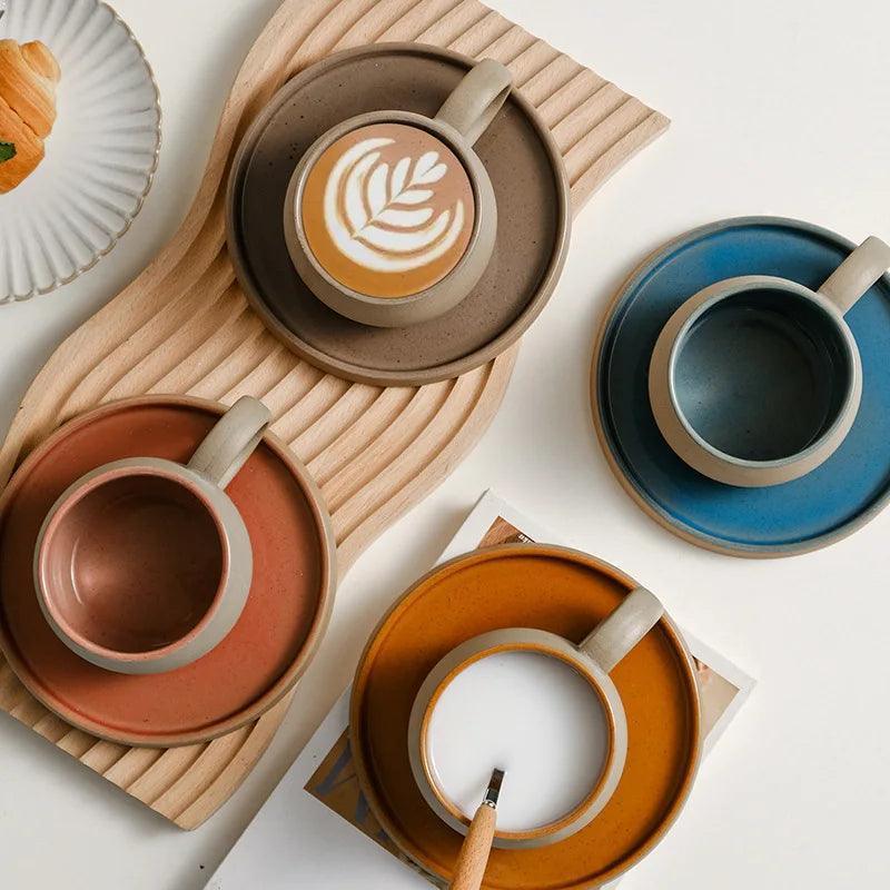 Four-color ceramic coffee cup and saucer collection with varied interior glazes
