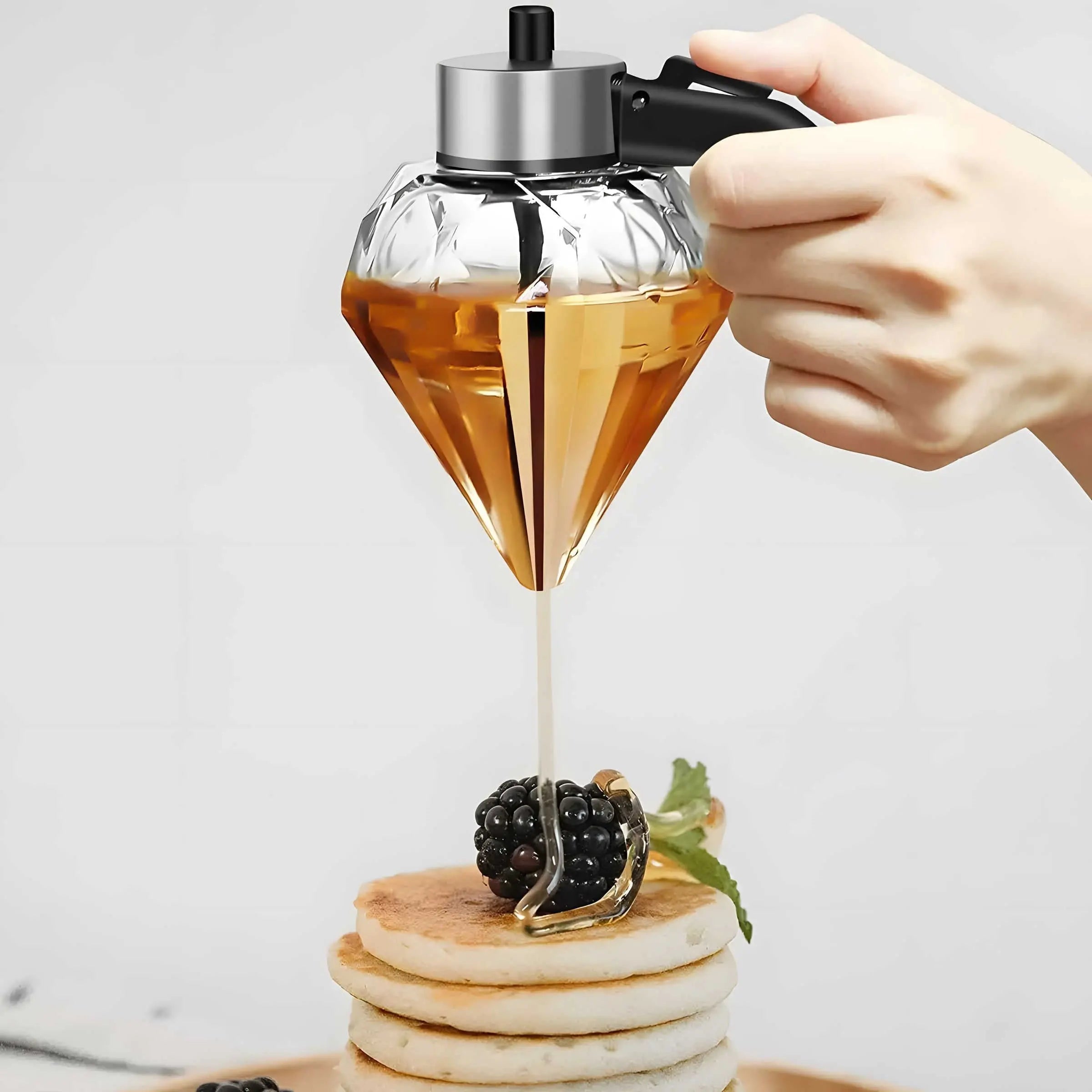 Honey dispenser bottle pouring amber liquid onto pancakes
