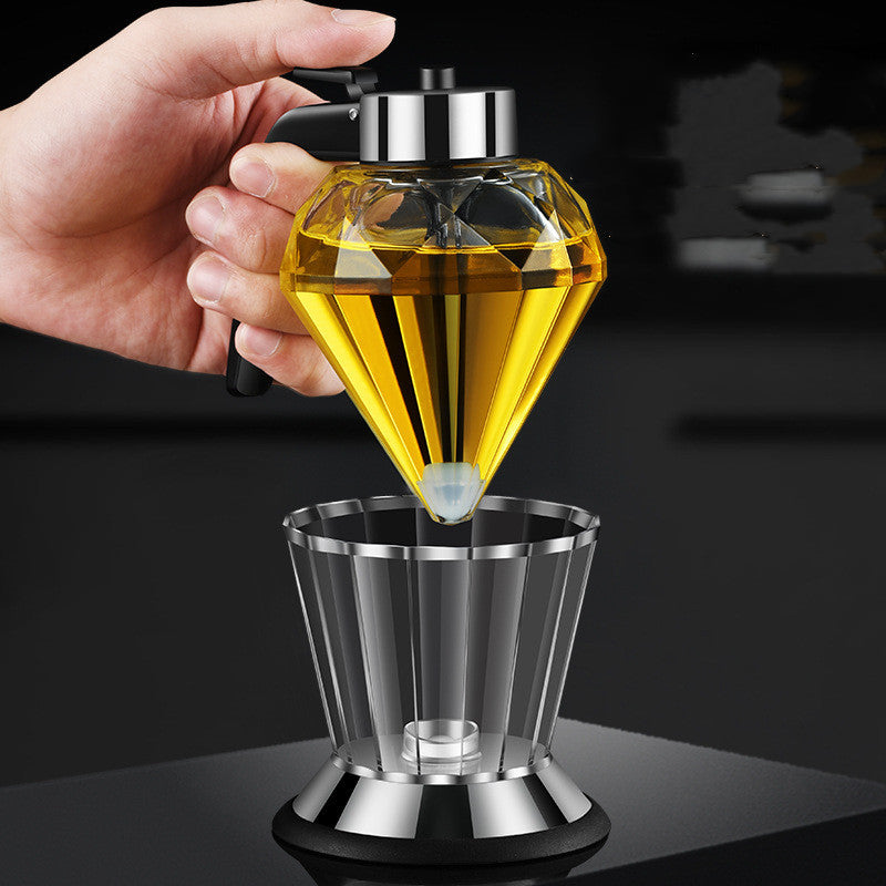 Hand pressing thumb lever on drip-free glass oil cruet