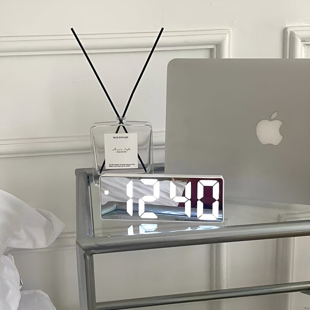 Sleek black framed LED mirror clock reflecting laptop on glass shelf