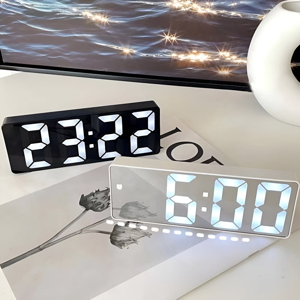 Silver and black digital mirror alarm clocks displaying time side by side