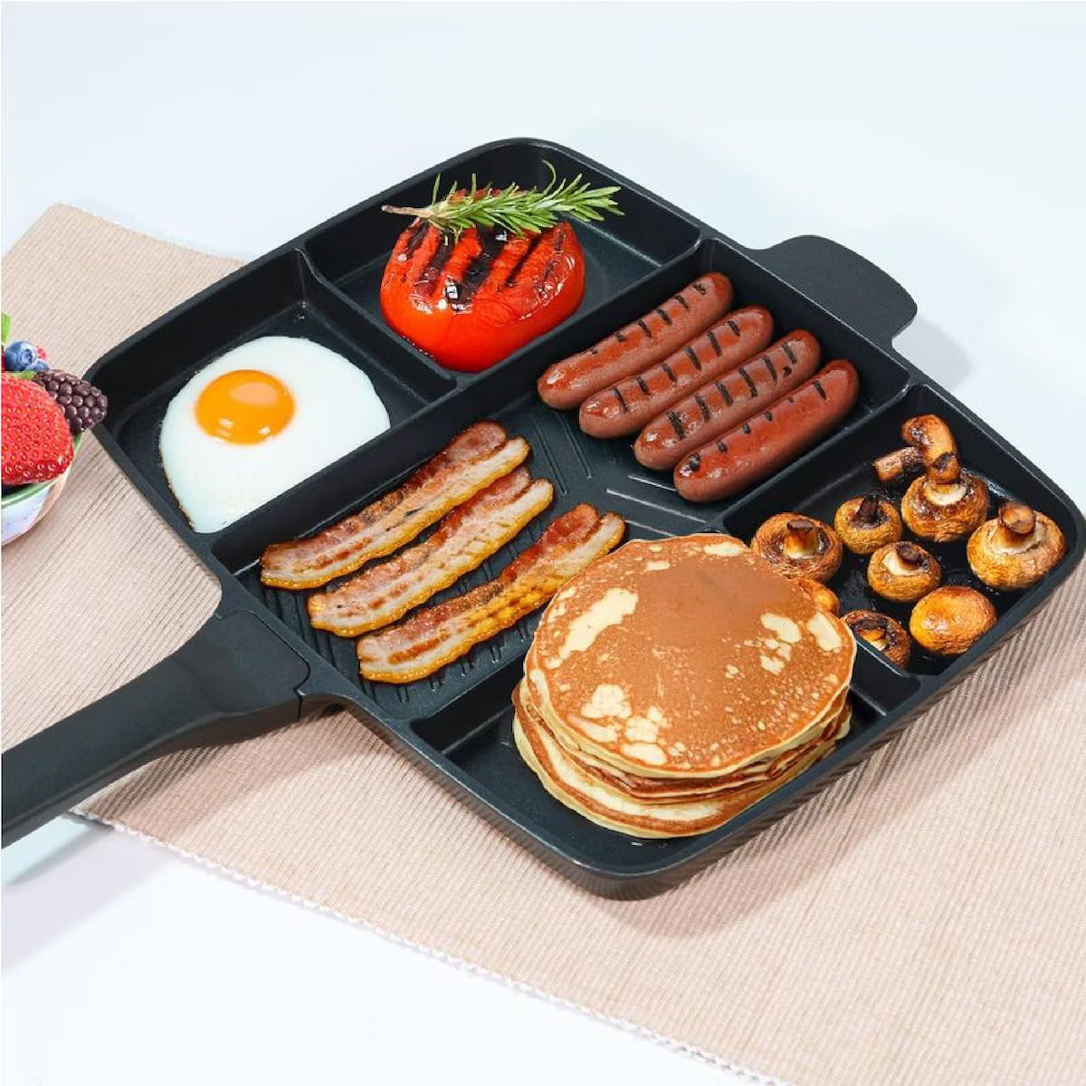 Five-compartment nonstick skillet cooking eggs bacon sausages and pancakes