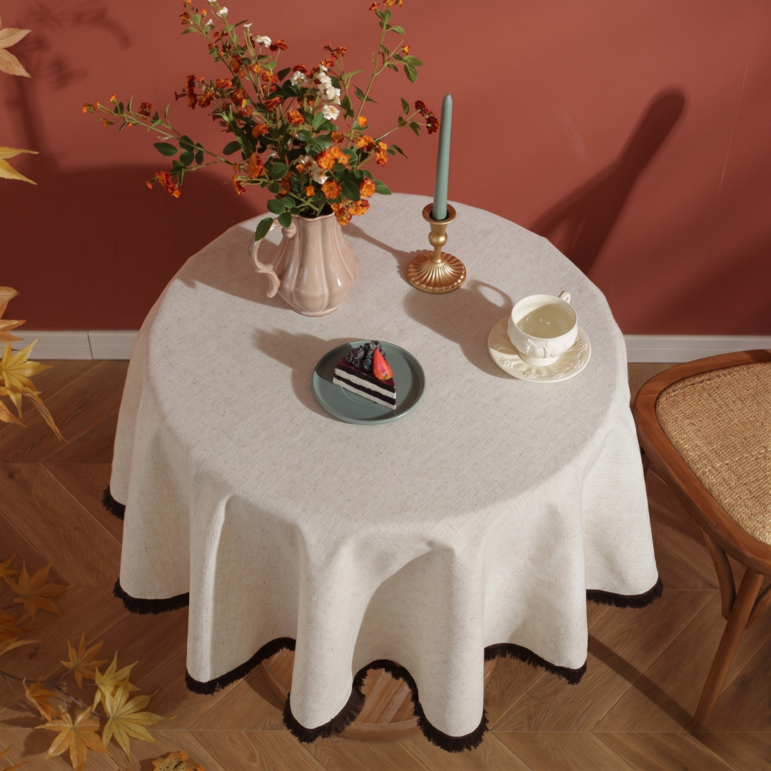 Cream tablecloth with brown tassels on autumn-themed table setting