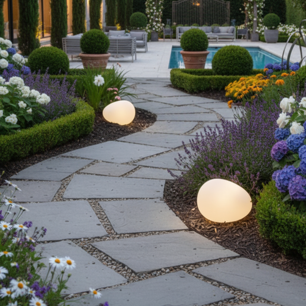Egg-shaped solar pathway lights beside manicured formal garden