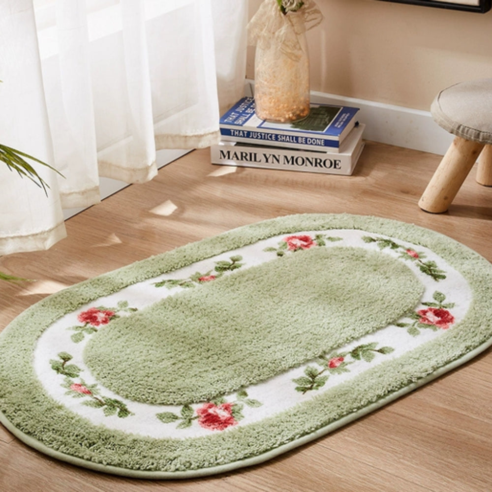 Light green oval bath mat with red rose floral border in bright bathroom setting