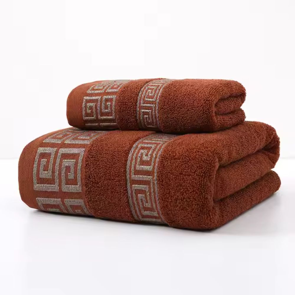 Rust terracotta bath towels with silver-gray meander fret border embroidery