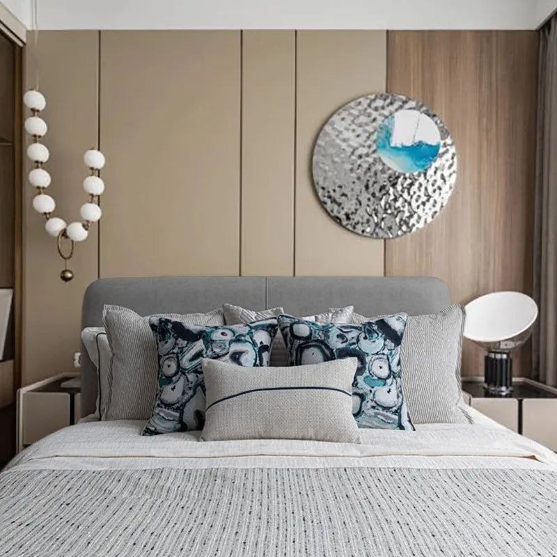 Teal abstract jacquard velvet throw pillow on gray upholstered bed