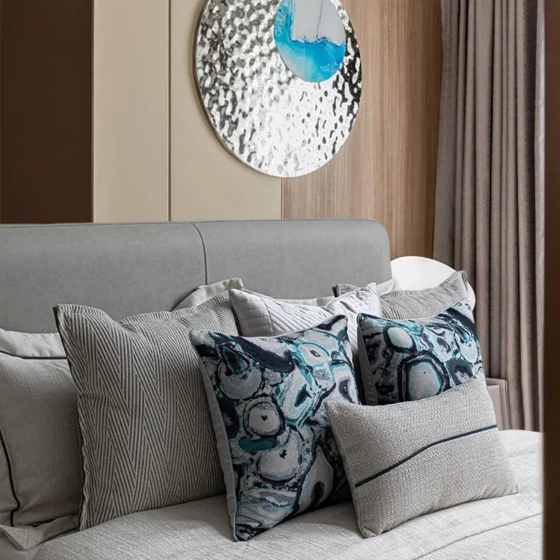 Layered gray herringbone and teal abstract pattern accent pillows