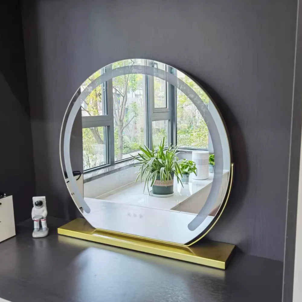 Gold tabletop vanity mirror with soft LED glow on dark desk
