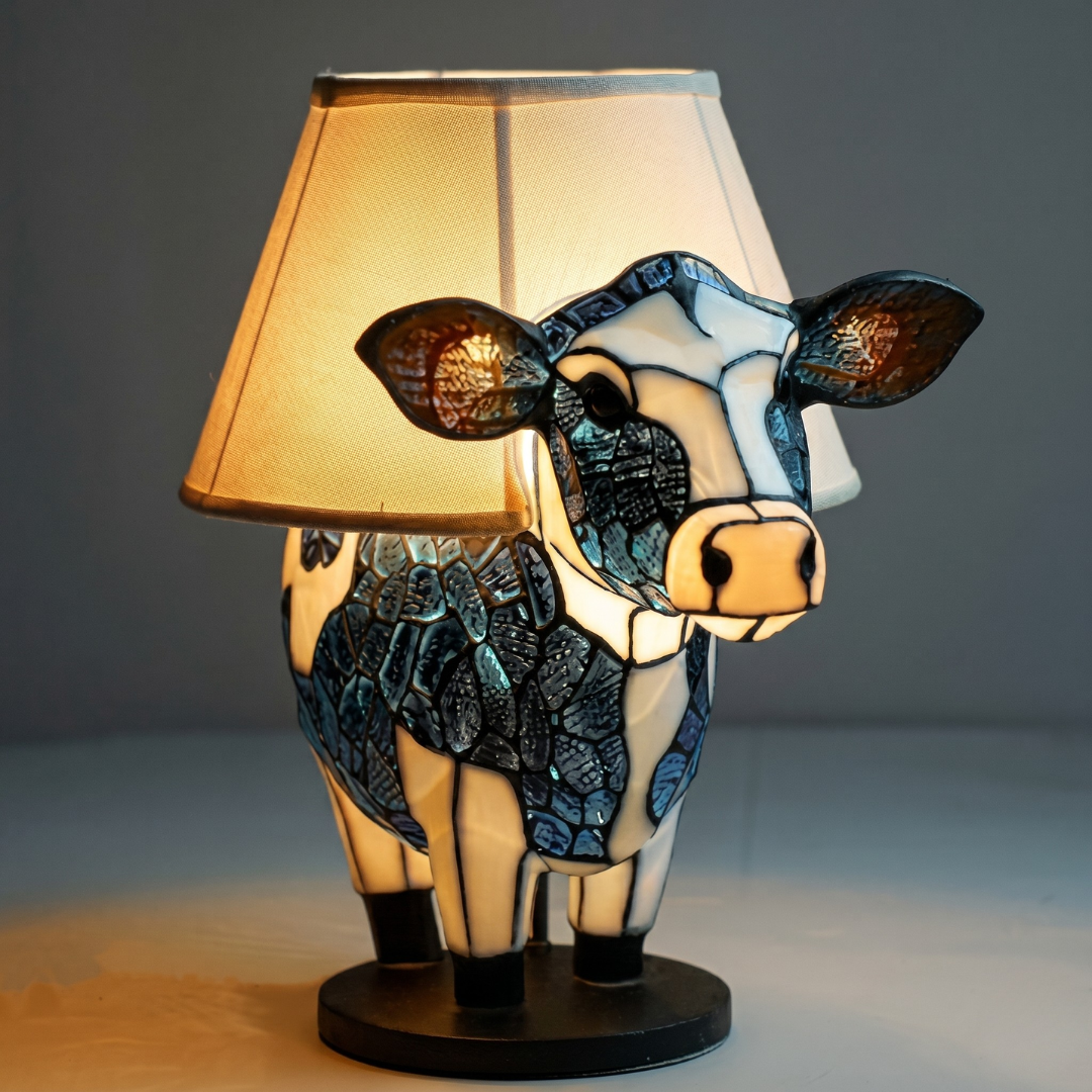 Cow-shaped stained glass table lamp with fabric shade and warm glow