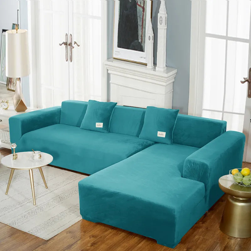 Teal stretch velvet sofa cover on sectional with 'hello' labeled pillows