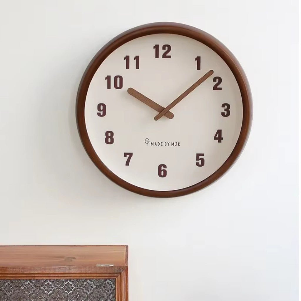 Cream dial wooden wall clock mounted above ornate furniture piece