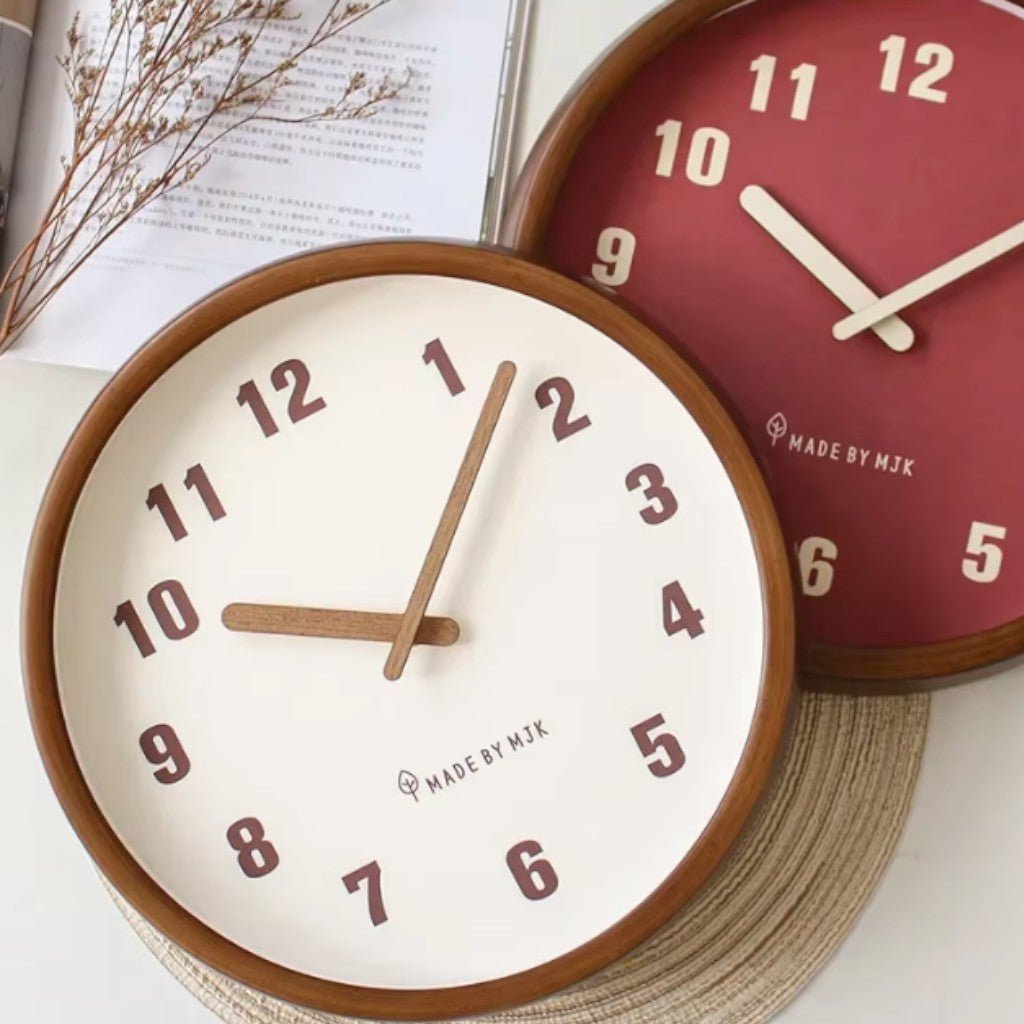 Red and cream wooden wall clocks on woven mat with book and flowers
