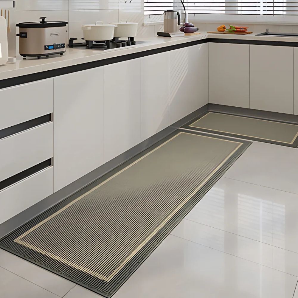 Gray-green kitchen runner mat with dark brown border on white tiled floor