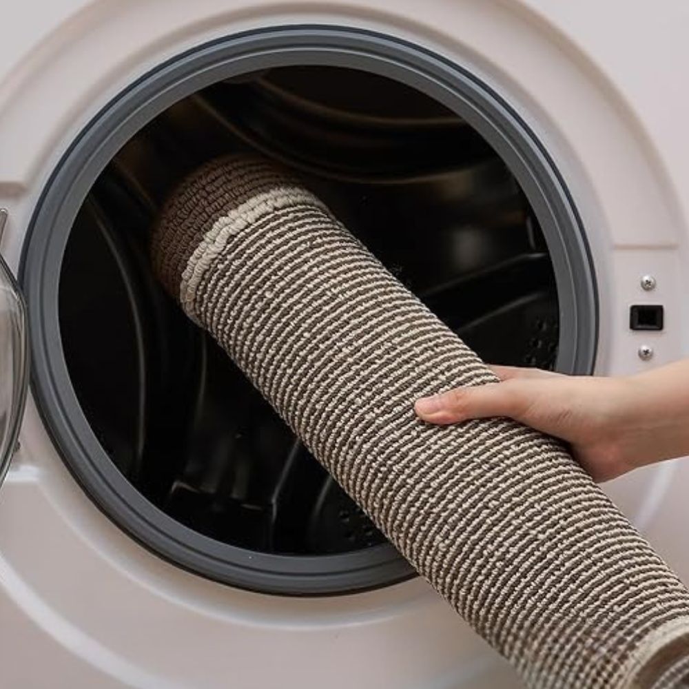 Rolled washable polypropylene kitchen mat being loaded into washing machine