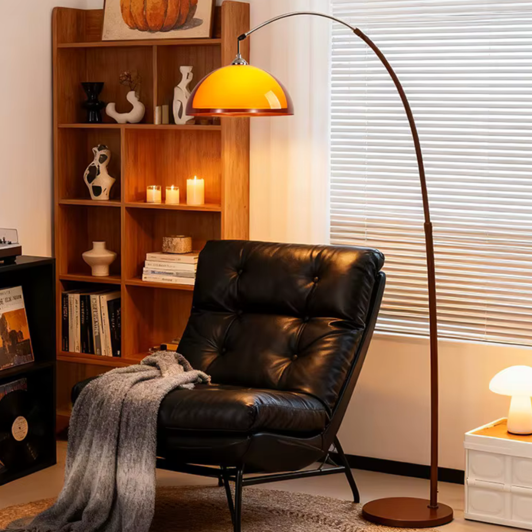 Adjustable height arched floor lamp illuminating black leather armchair reading nook