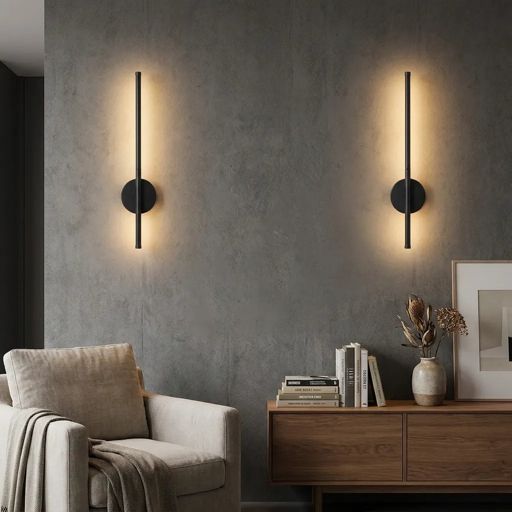 Symmetrical black wall lamps flanking armchair