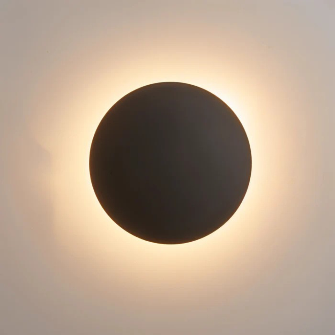 Black circular wall mounted light with even warm white ambient glow