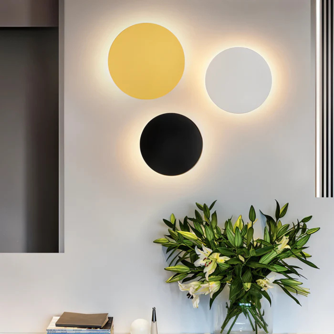 Set of three modern wall lights in yellow, white, and black with warm glow
