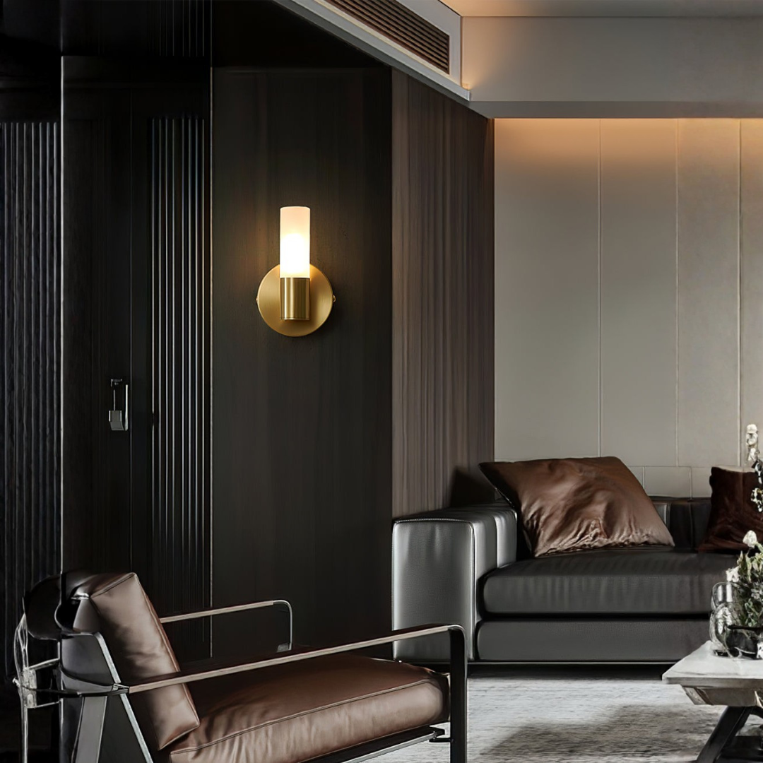 Dual-directional brass wall lamp beside leather sofa and armchair