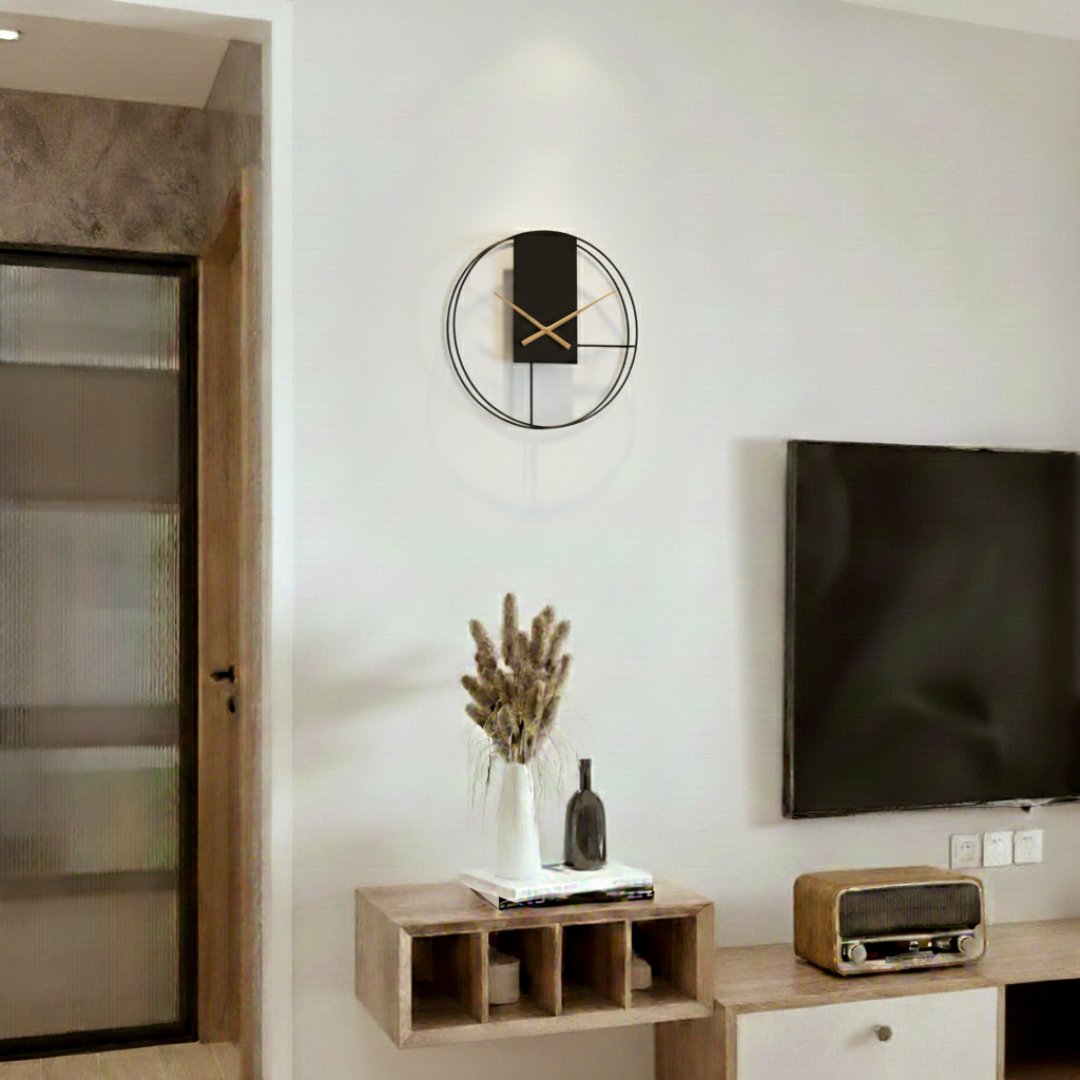 Contemporary black circular wall clock with gold accents on white wall