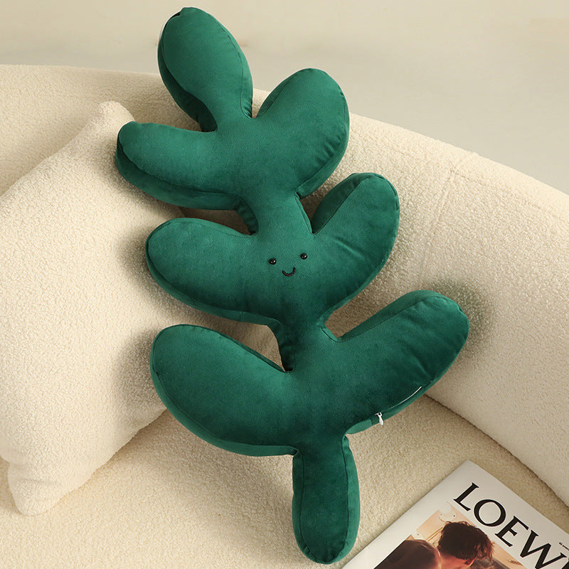 Cute monstera leaf shaped pillow with embroidered smiling face