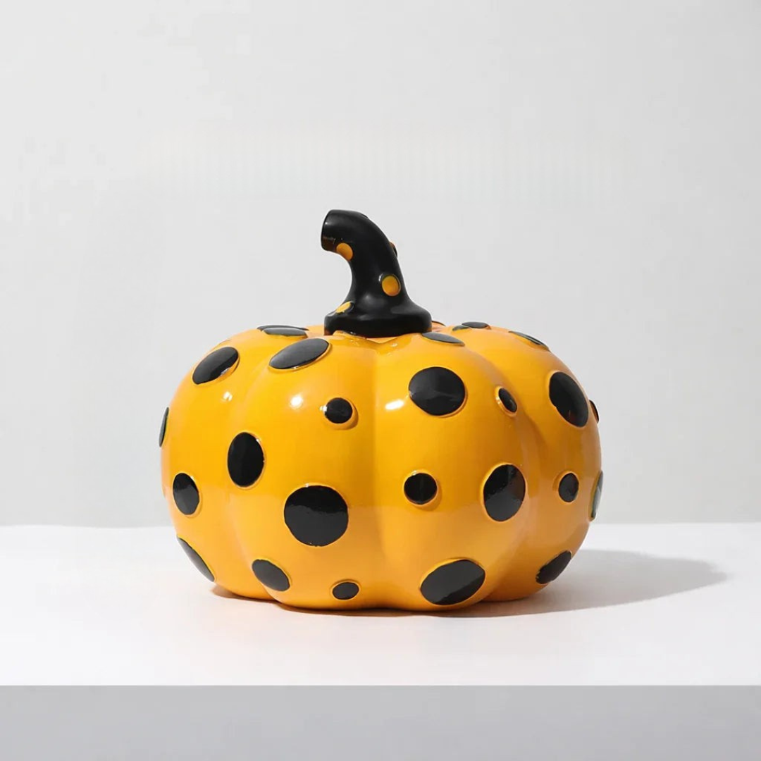 Close up of yellow polka dot pumpkin figurine featuring sculpted black stem detail