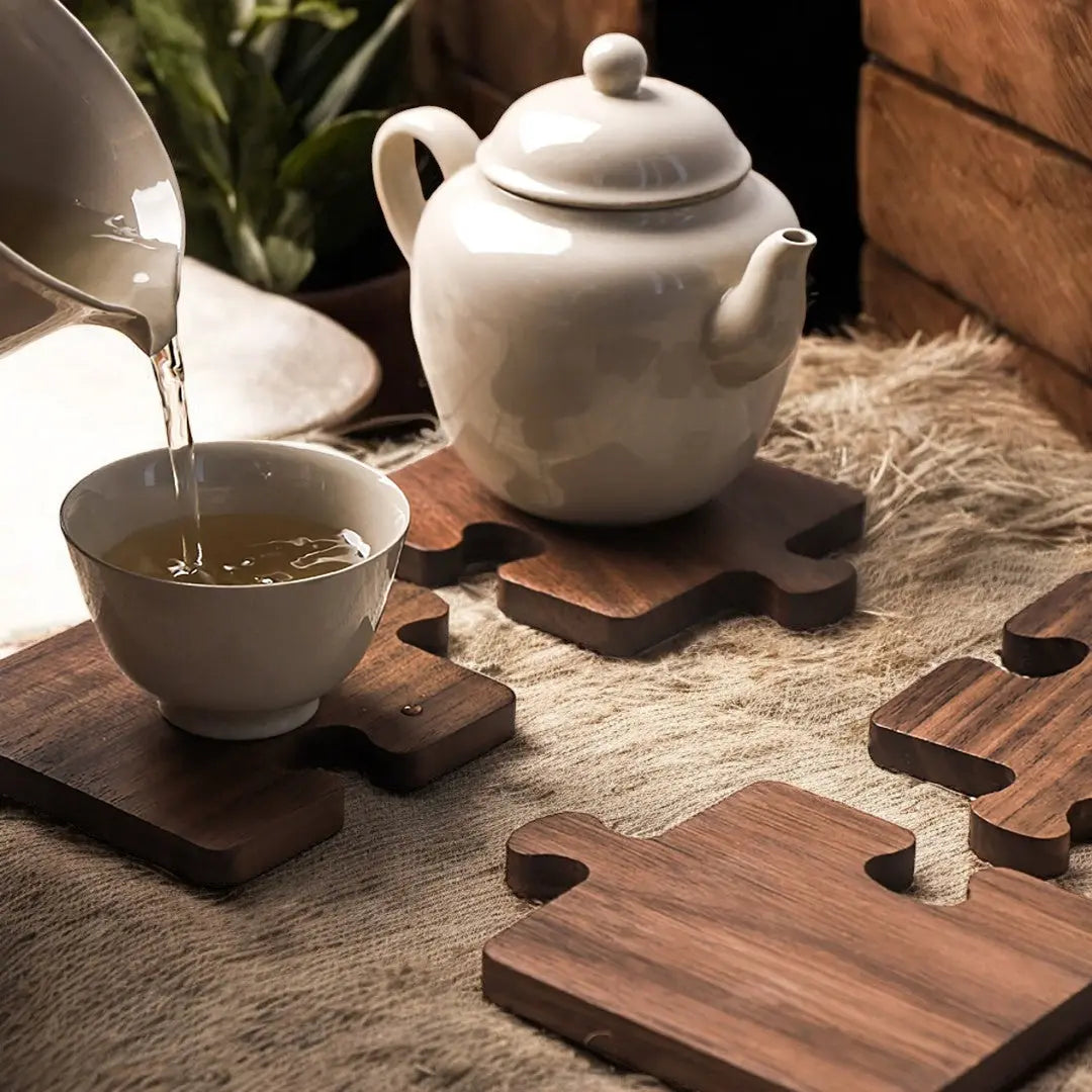 Interlocking walnut wood drink coasters arranged with white teapot and cups
