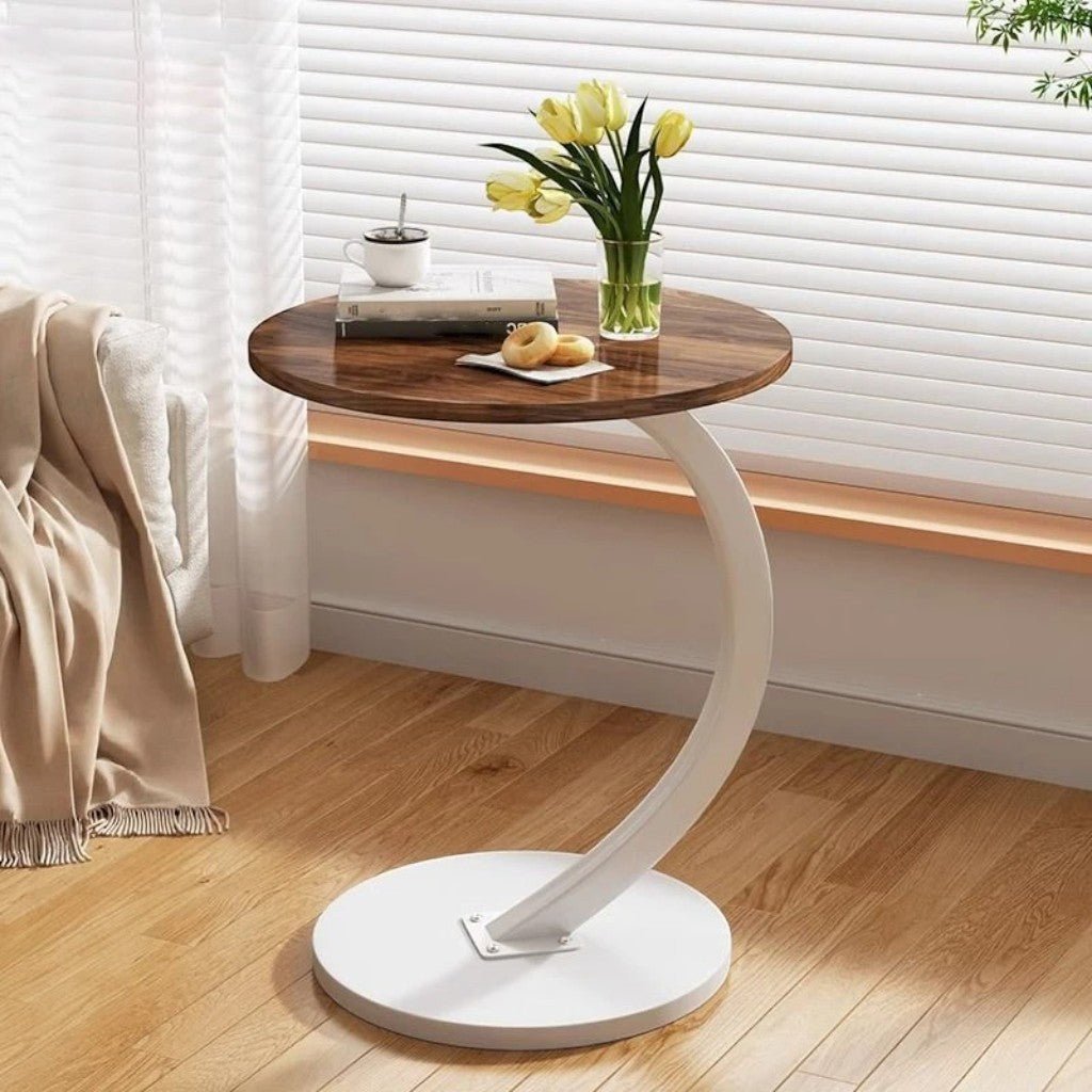 Round C-shaped sofa side table with white metal base in living room