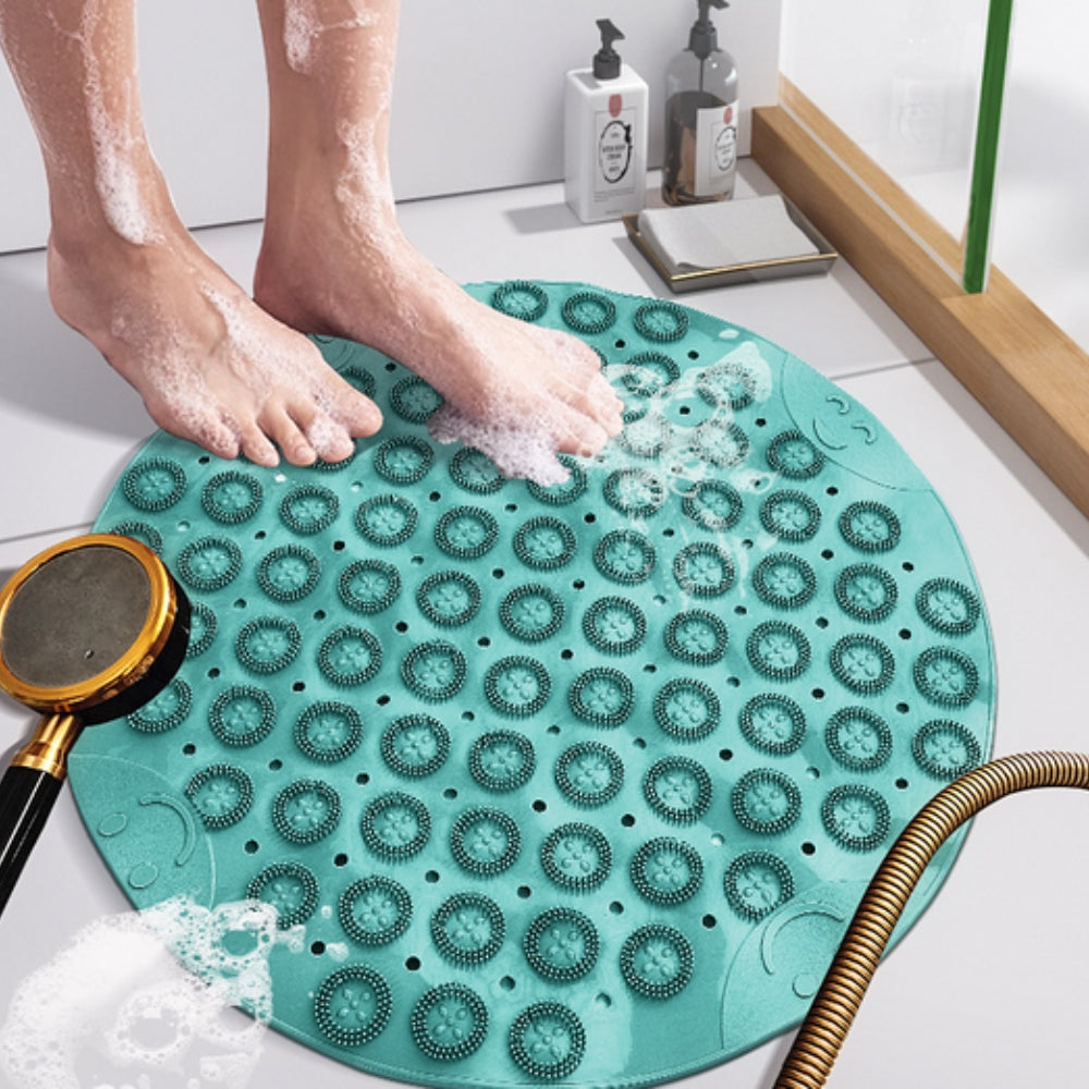 Round teal silicone shower mat with foot massaging bristles and non-slip suction cups
