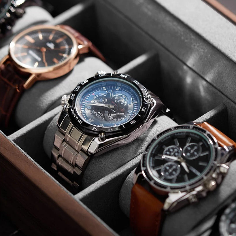Interior view of padded watch box slots featuring rose gold and steel chronographs
