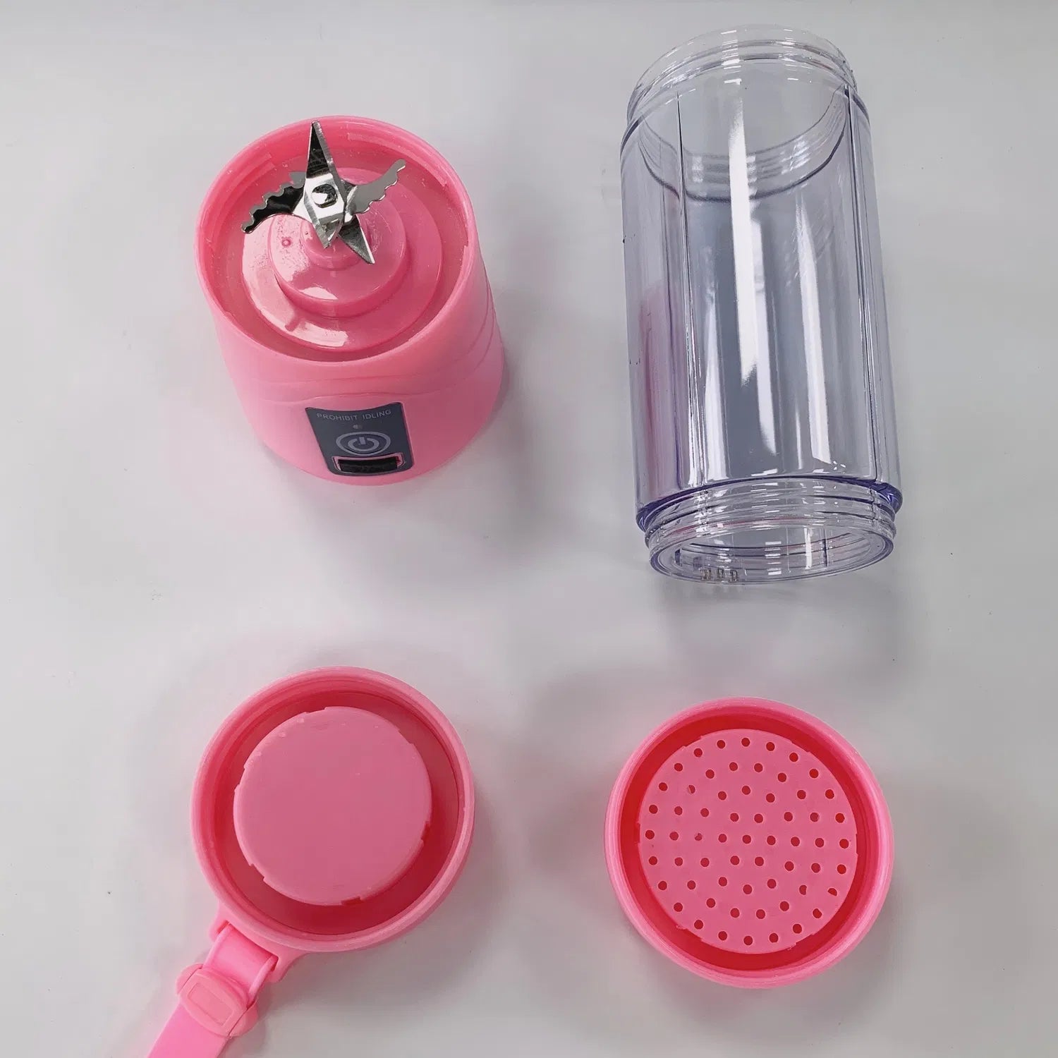 Disassembled pink portable blender showing 5-blade propeller and filter insert