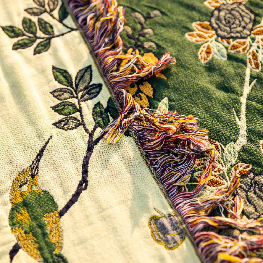 Close-up of reversible woven cotton blanket seam showing cream and green botanical patterns