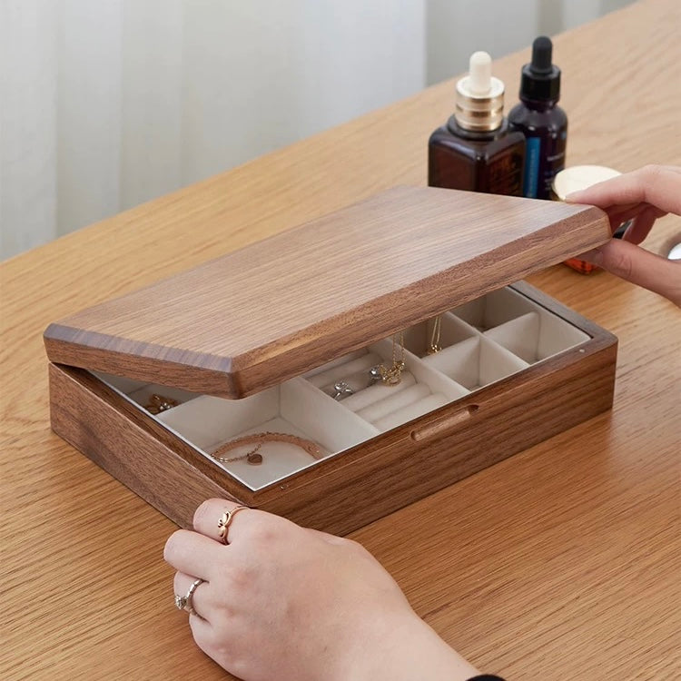 Hands opening walnut jewelry box with necklace and bracelet storage