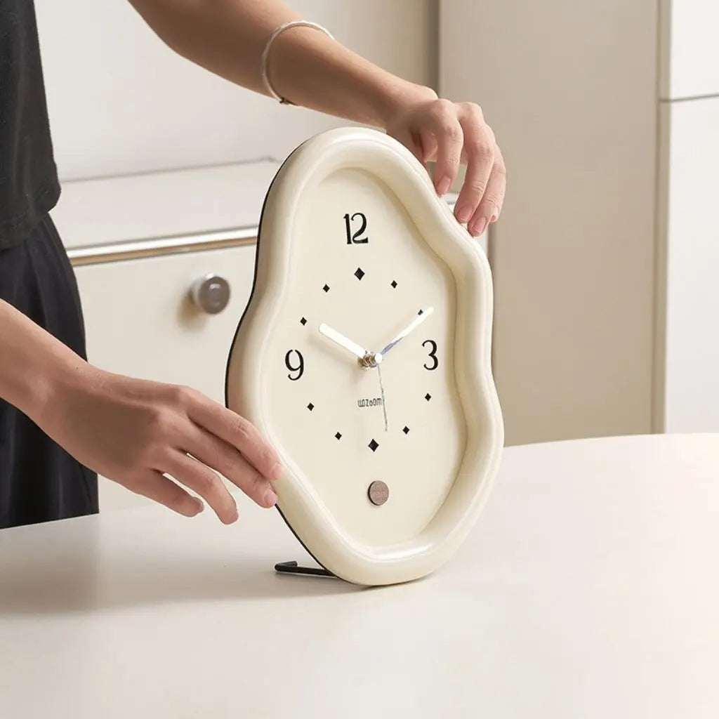 Off-white wavy table clock with organic silhouette and minimalist face