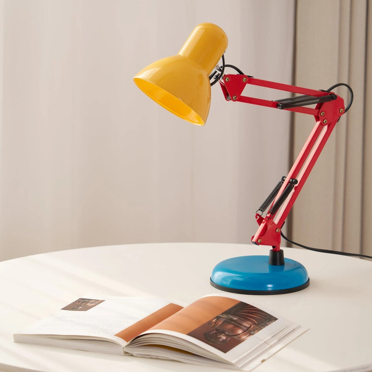 Maintained House Architect Desk Lamp - Color Block on a table with an open book