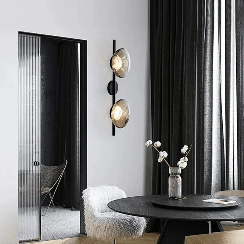 Maintained House Nordic Rippled Glass Wall Sconce - Two Disc on Rod in Smoke Gray Glass / Black beside a dining table
