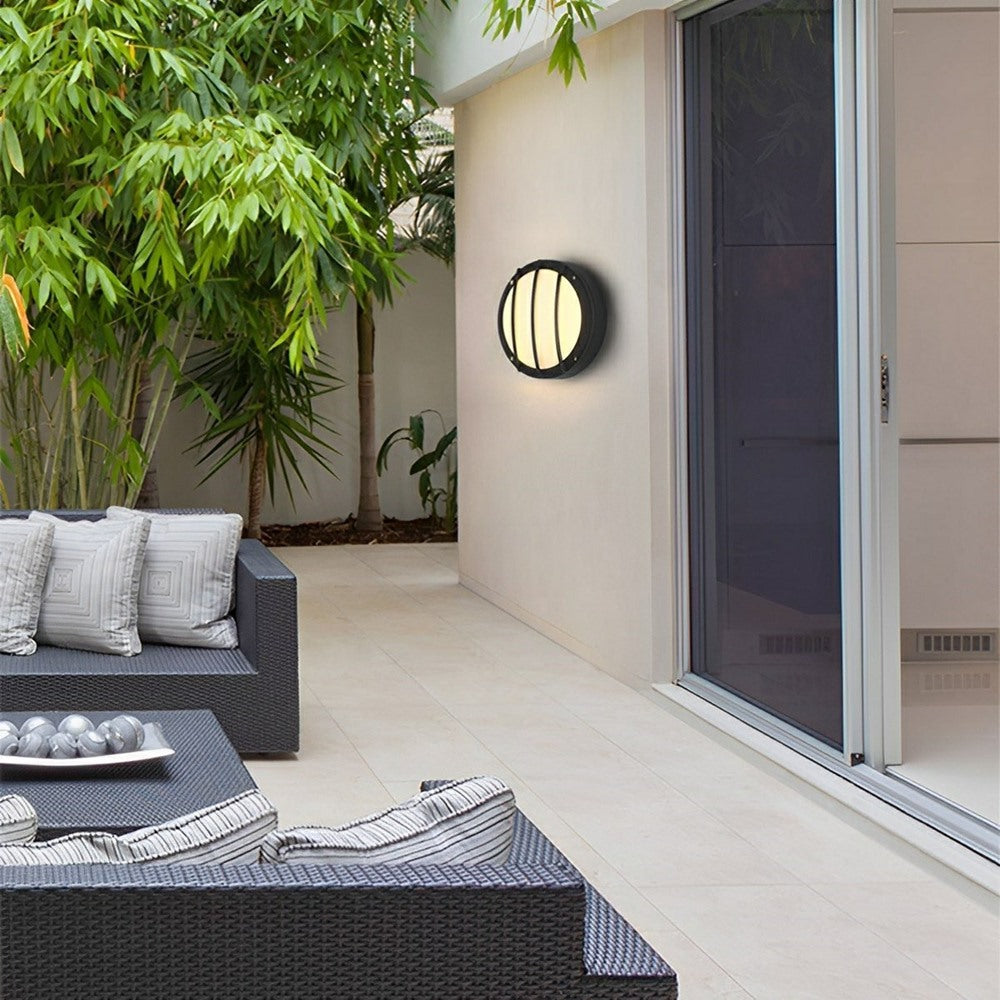 Maintained House Round Outdoor LED Wall Light - Bars style on a courtyard wall