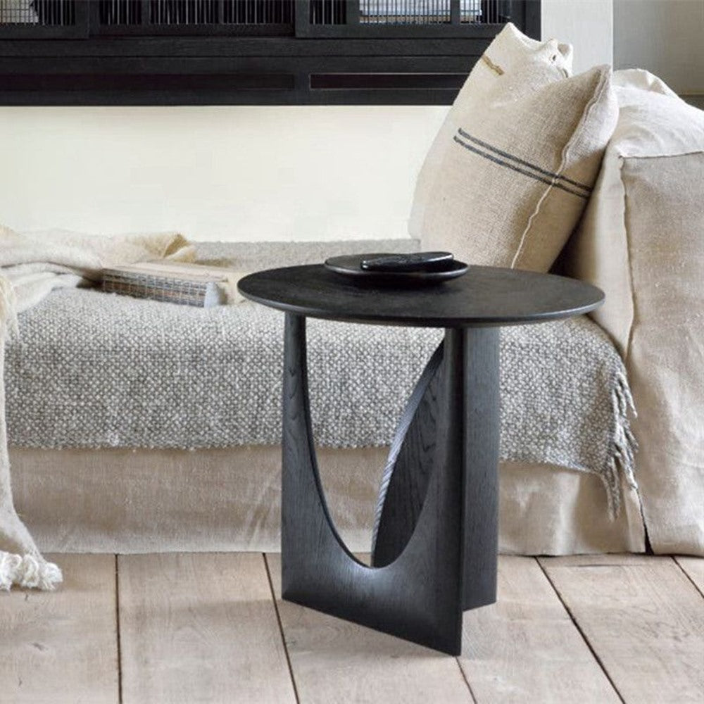 Maintained House Sculpted Round Side Table - Charcoal Black beside a sofa