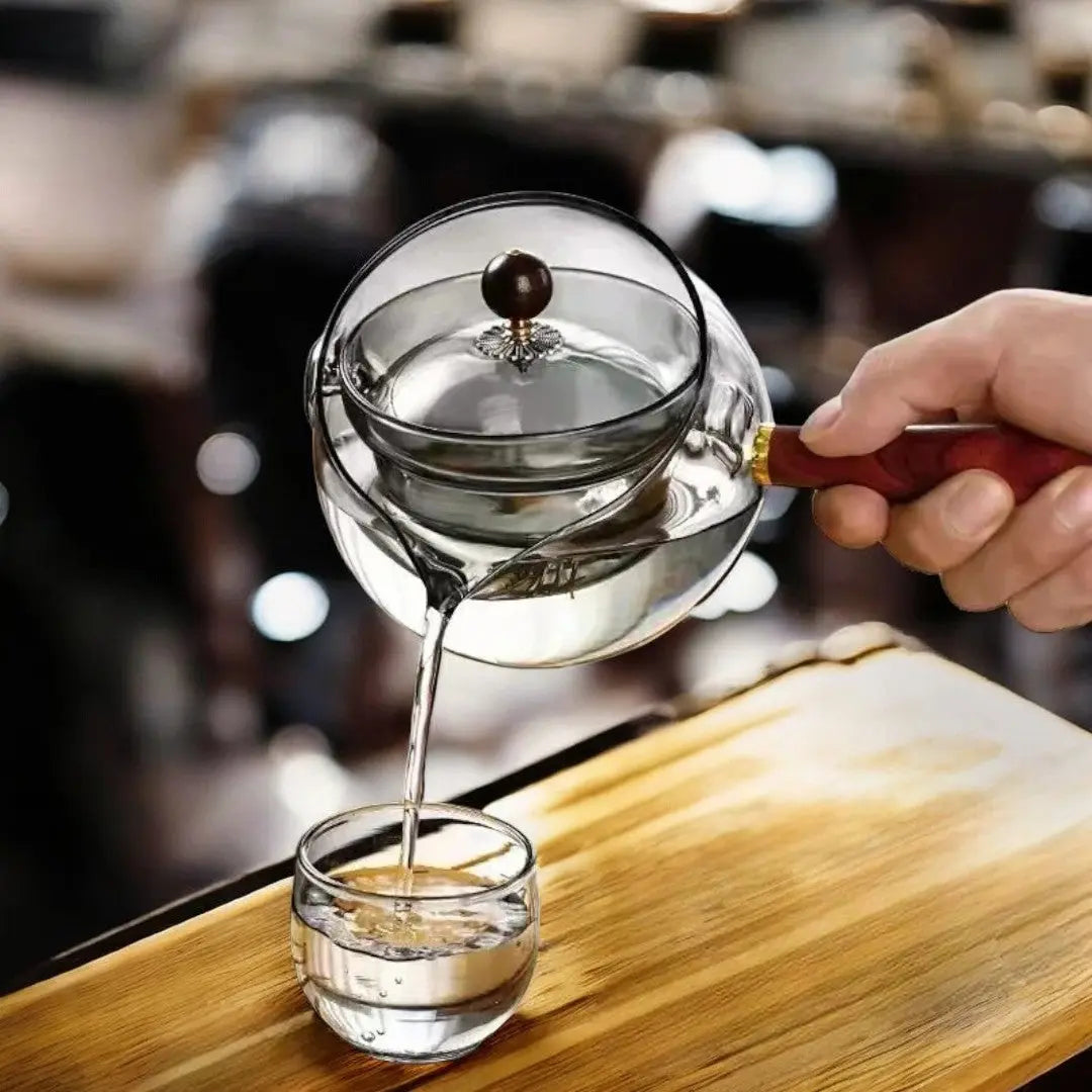 Smoked gray rotating glass teapot with wood handle pouring loose leaf tea