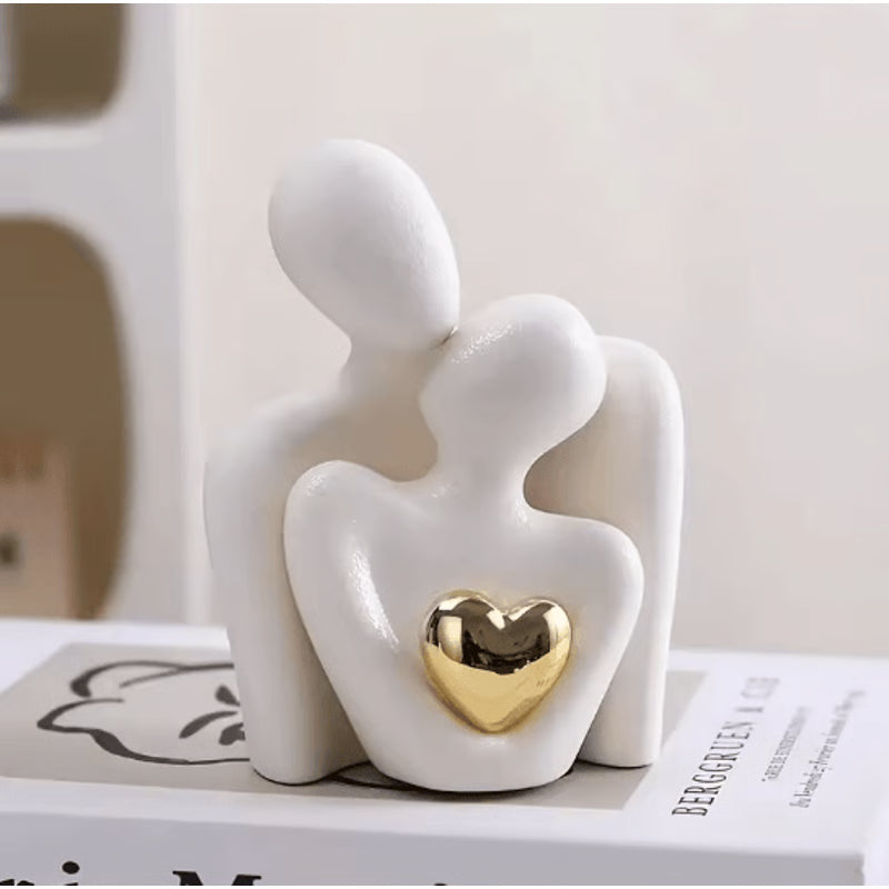 Minimalist white ceramic couple sculpture with gold heart detail