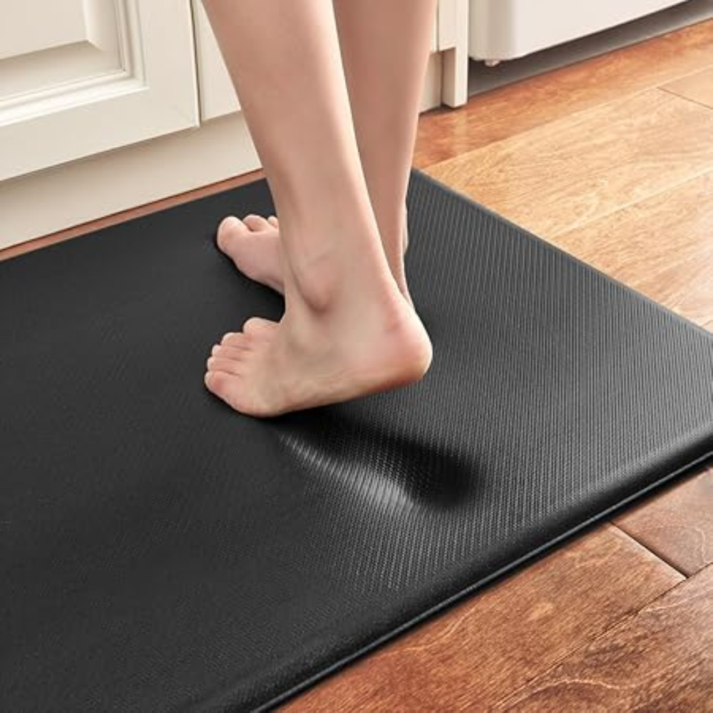 Close-up of thick black ergonomic kitchen mat with diagonal ribbed texture under feet