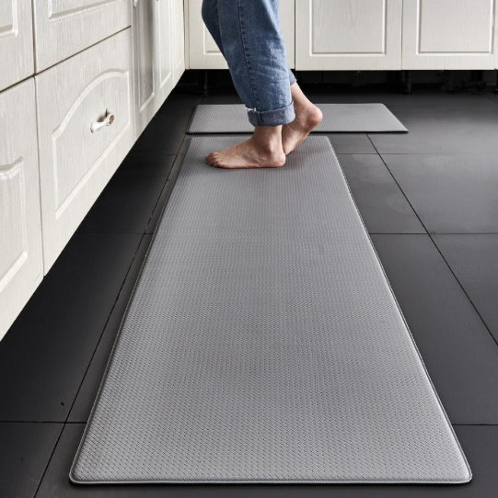 Gray non-slip kitchen floor mat runner with diamond pattern on dark tile